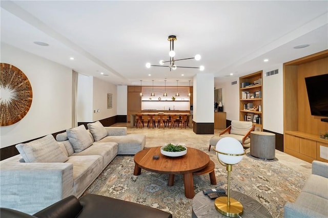 living room featuring an inviting chandelier and built in shelves