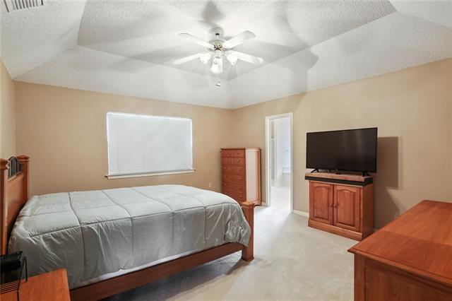 bedroom with a tray ceiling, ceiling fan, and light colored carpet