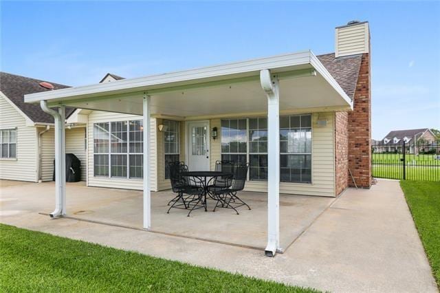 back of property with a yard and a patio