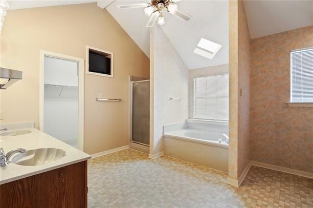 bathroom with independent shower and bath, vaulted ceiling with skylight, ceiling fan, and tile flooring