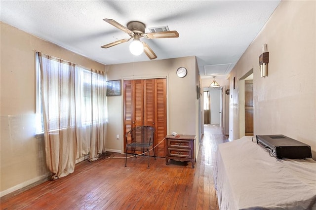 bedroom with dark hardwood / wood-style flooring, ceiling fan, and a closet