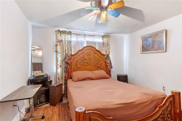 bedroom featuring a textured ceiling, hardwood / wood-style floors, and ceiling fan