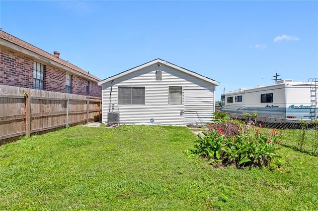 back of house with a yard and central air condition unit