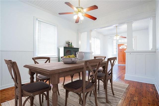 dining space with crown molding, ceiling fan, ornate columns, and dark hardwood / wood-style flooring