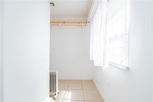 spacious closet featuring light tile patterned flooring and radiator