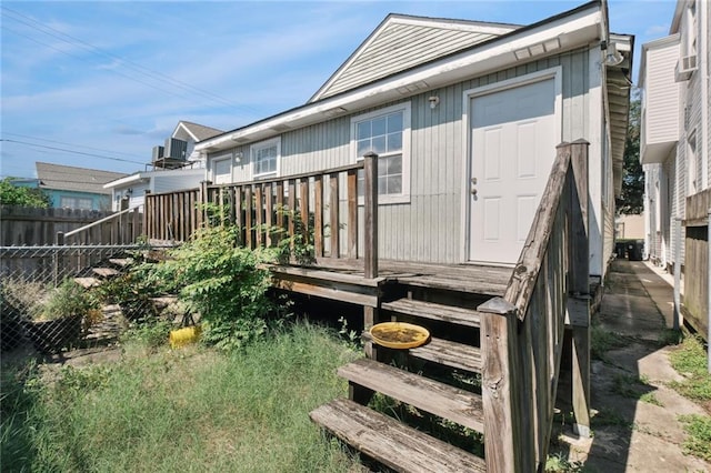 back of property featuring a storage unit and a deck