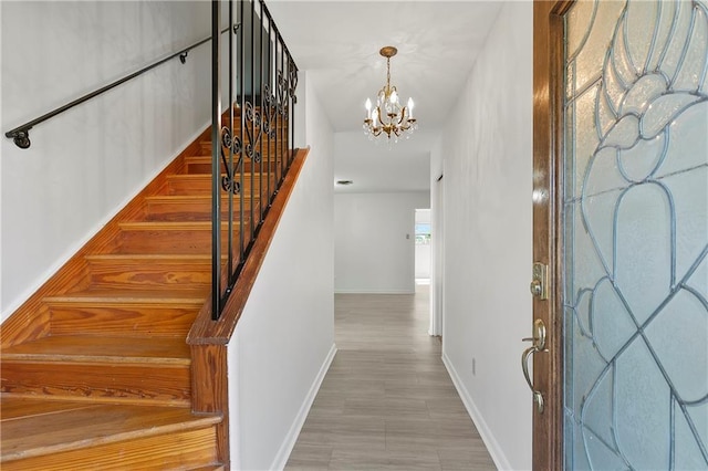 staircase featuring a notable chandelier and wood-type flooring