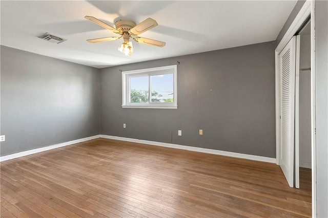 unfurnished bedroom with a closet, ceiling fan, and hardwood / wood-style floors