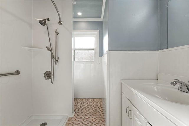 bathroom featuring tile patterned floors, vanity, a shower, and crown molding