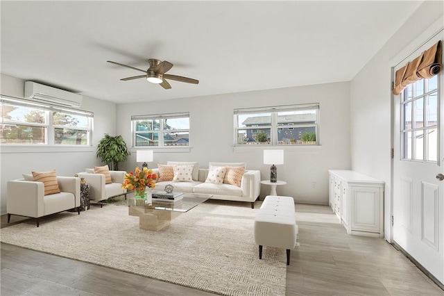 living room with an AC wall unit and ceiling fan