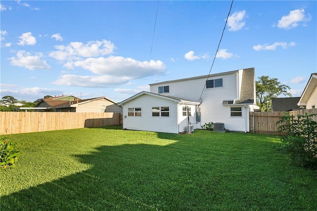 back of property featuring a lawn and central air condition unit