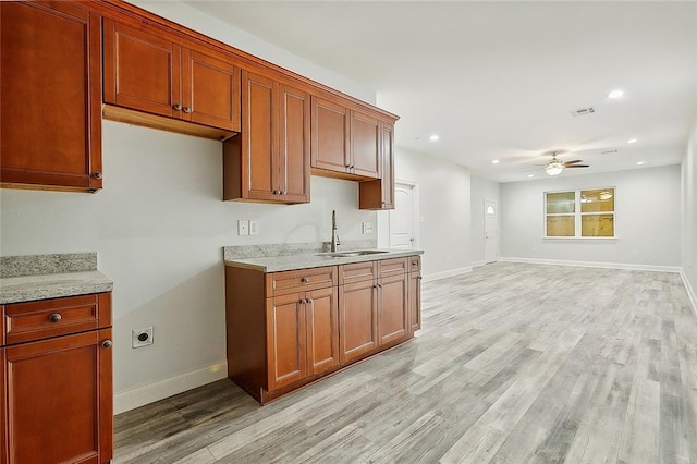 kitchen featuring light hardwood / wood-style flooring, sink, and ceiling fan