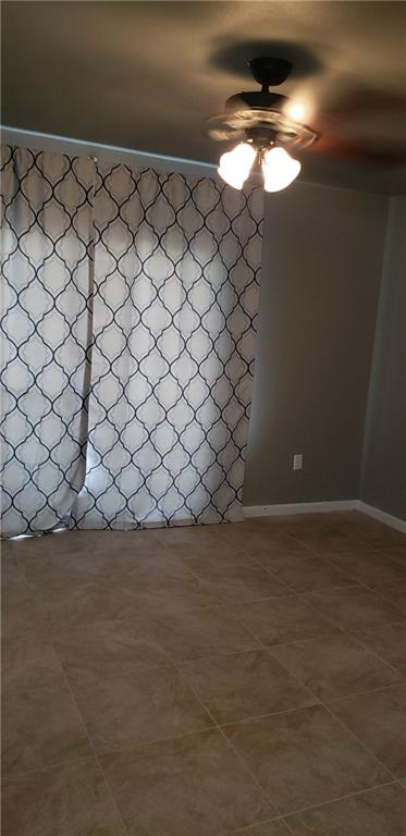 tiled empty room with ceiling fan