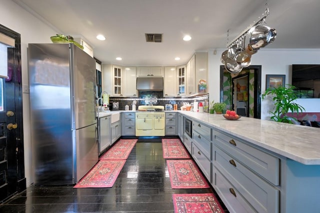 kitchen with appliances with stainless steel finishes, tasteful backsplash, ornamental molding, and gray cabinetry