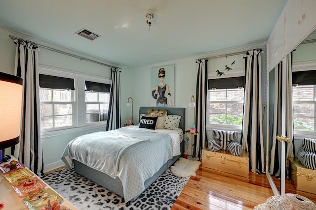 bedroom with multiple windows and light wood-type flooring