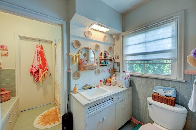 full bathroom with tile walls, shower / bathtub combination with curtain, toilet, and vanity