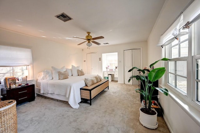 carpeted bedroom with ceiling fan and multiple windows