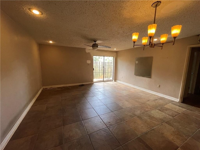 spare room featuring ceiling fan with notable chandelier and a textured ceiling