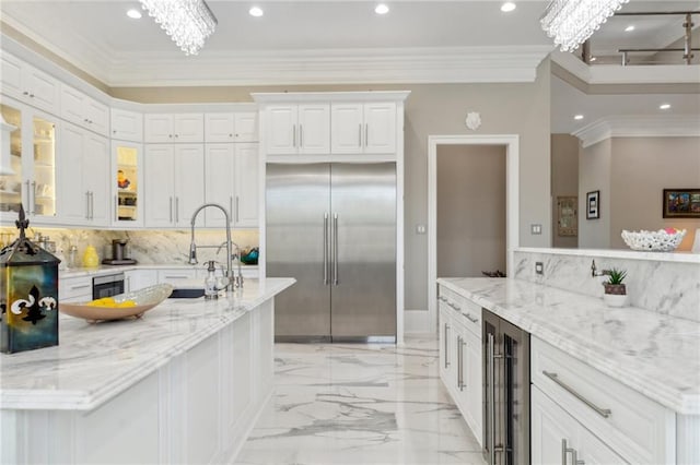 kitchen featuring a notable chandelier, light stone countertops, wine cooler, and built in refrigerator