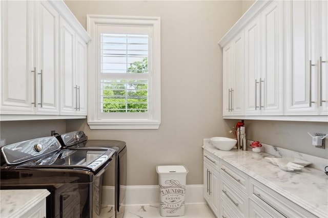 laundry room with washer and dryer, cabinets, and sink