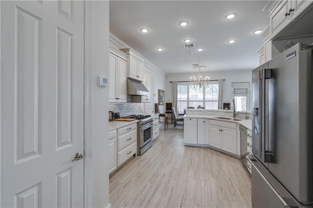 kitchen with backsplash, white cabinetry, pendant lighting, and high end appliances