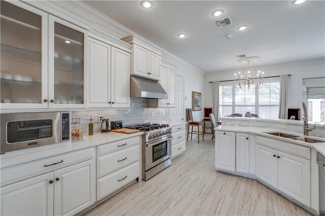 kitchen featuring appliances with stainless steel finishes, sink, tasteful backsplash, white cabinetry, and pendant lighting