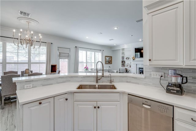 kitchen featuring pendant lighting, white cabinets, crown molding, sink, and stainless steel dishwasher