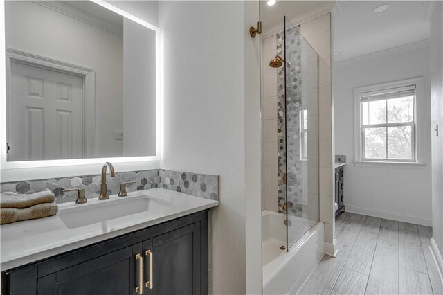 bathroom featuring ornamental molding, shower / bath combination with glass door, and vanity