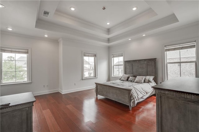 bedroom with ornamental molding, dark hardwood / wood-style flooring, multiple windows, and a tray ceiling