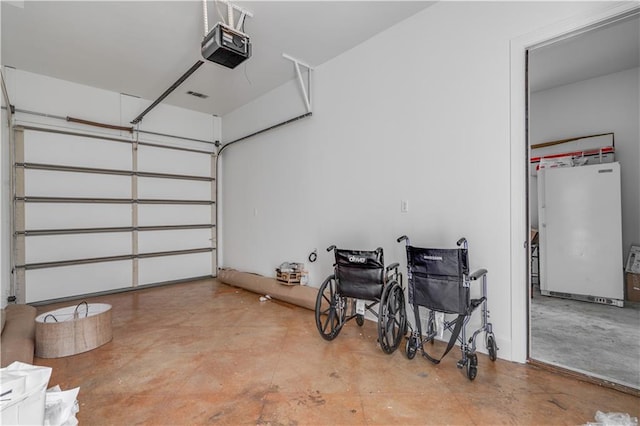 garage featuring white refrigerator and a garage door opener