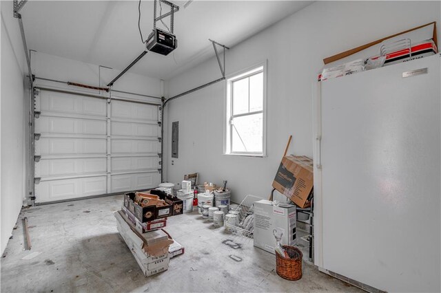 garage featuring white refrigerator and a garage door opener