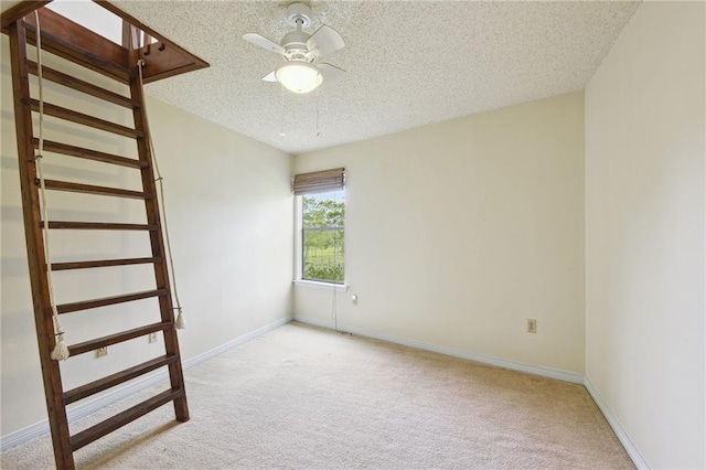 carpeted empty room with a textured ceiling and ceiling fan