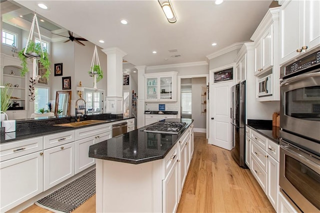 kitchen featuring crown molding, light hardwood / wood-style flooring, appliances with stainless steel finishes, white cabinets, and ceiling fan