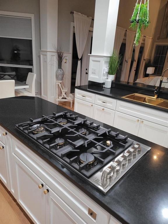 kitchen with sink, white cabinetry, and black gas stovetop