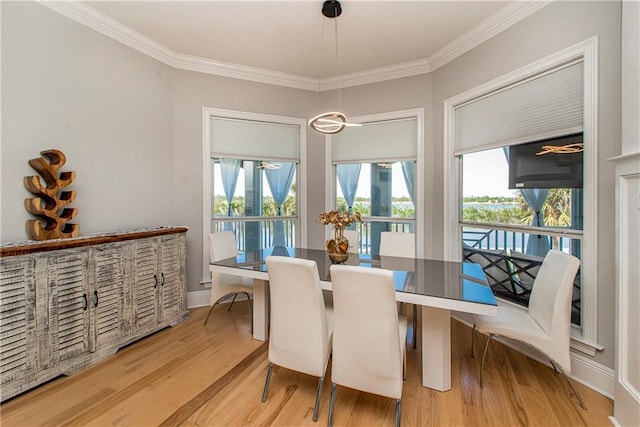 dining space with crown molding and light wood-type flooring