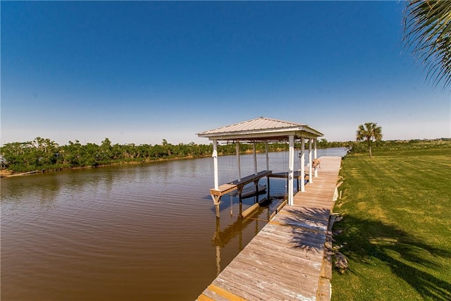 view of dock with a water view and a yard