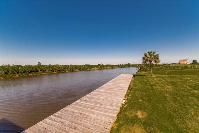 view of dock featuring a lawn and a water view