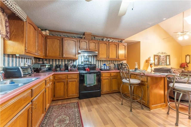 kitchen featuring ceiling fan, electric range oven, light hardwood / wood-style floors, vaulted ceiling, and kitchen peninsula