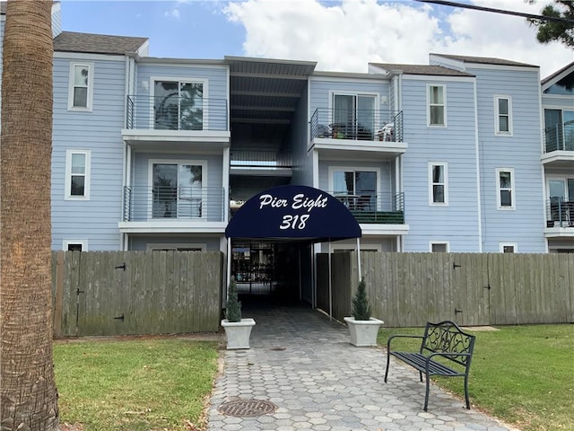 view of front of property with a front lawn and a balcony