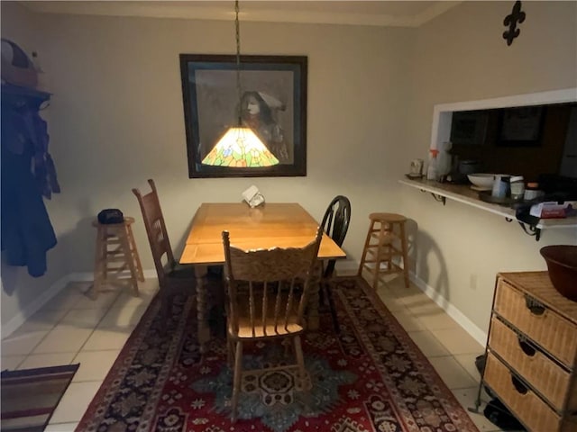 tiled dining room featuring ornamental molding