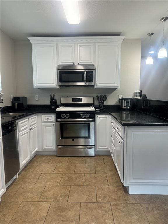 kitchen featuring pendant lighting, stainless steel appliances, sink, and white cabinetry