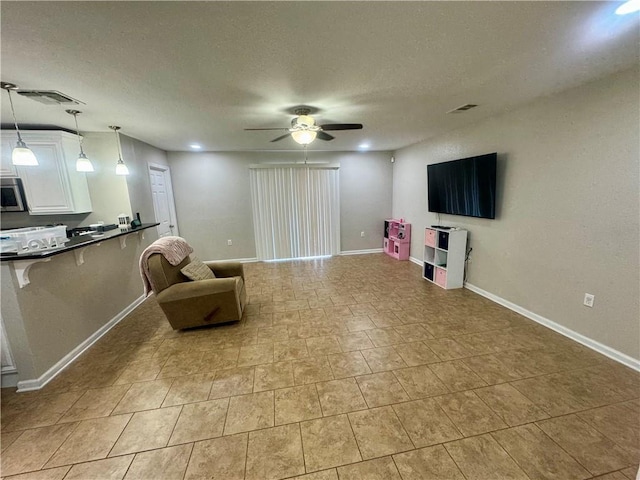 sitting room featuring a textured ceiling and ceiling fan