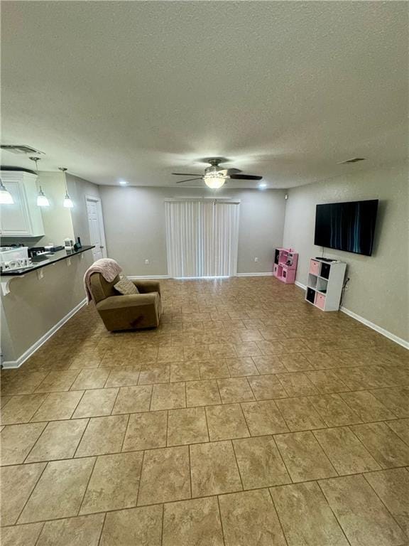 unfurnished room with a textured ceiling and ceiling fan