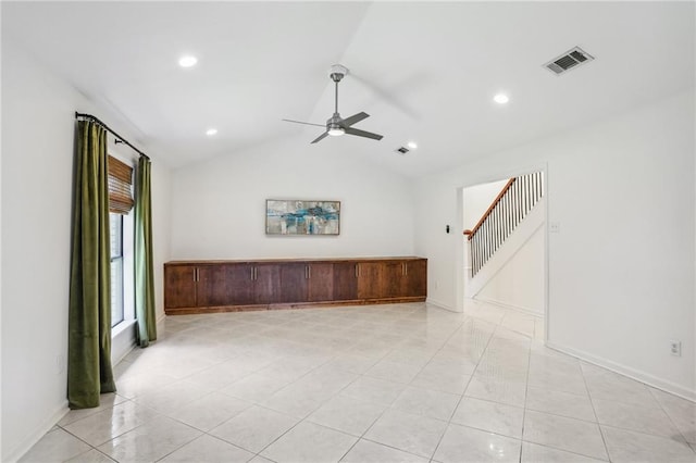 spare room with ceiling fan, vaulted ceiling, and light tile patterned floors