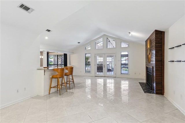 living room with lofted ceiling, a fireplace, and french doors