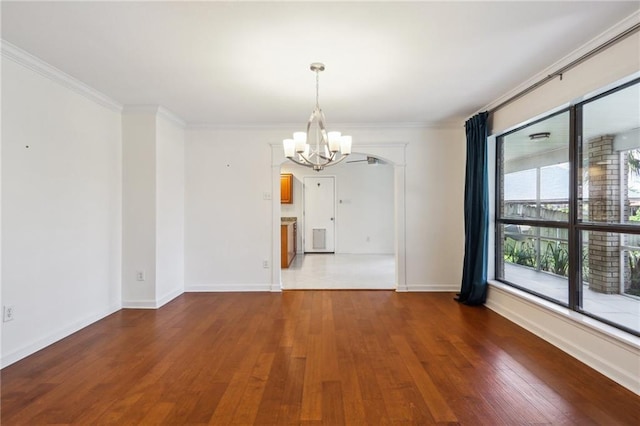 spare room featuring ornamental molding, hardwood / wood-style floors, and a notable chandelier