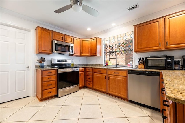 kitchen featuring light tile patterned flooring, appliances with stainless steel finishes, crown molding, and sink