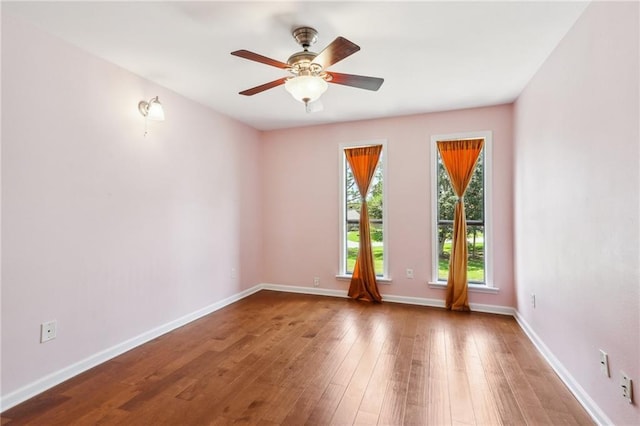 empty room with hardwood / wood-style floors and ceiling fan