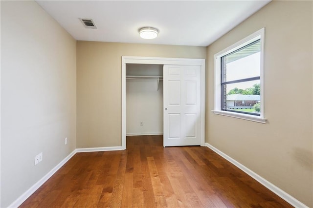 unfurnished bedroom featuring hardwood / wood-style flooring and a closet