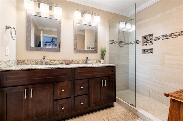 bathroom featuring crown molding, tiled shower, and vanity